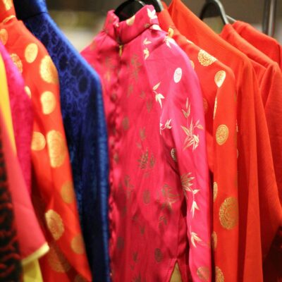 Traditional Japanese clothes of different bright colors with golden ornament hanging on cloth rack